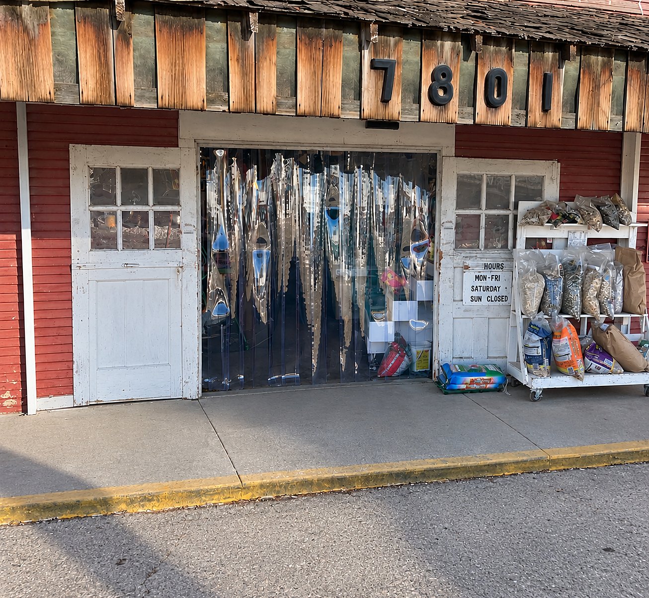 Before: a red barn-style storefront with an old wood door and a plastic strip curtain